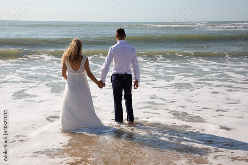 wedding bride and groom on a beach foot and legs in sea water © OceanProd