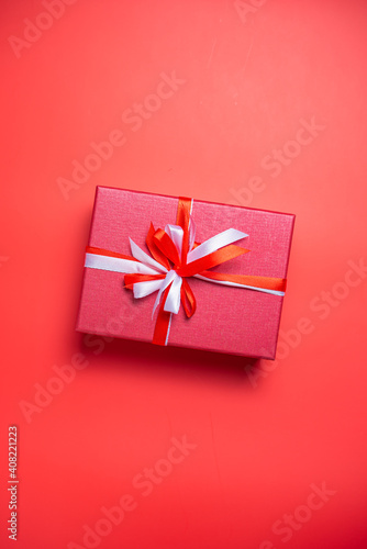 Red gift box with white and red bow on red background top view, Valentines day, Flat lay style with copy space. © teerawat