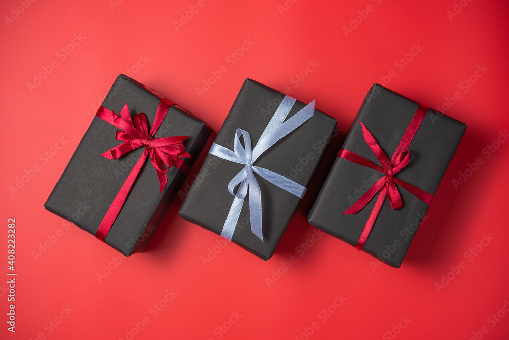 Black gift box with red bow and Black gift box with white bow on red background top view, Valentines day, Flat lay style with copy space. Black gift box with red bow and Black gift box with white bow on red background top view, Valentines day, Flat lay style with copy space.
