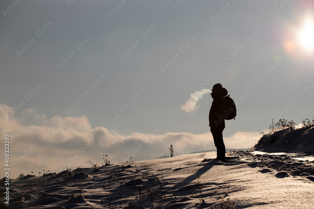 Silhouette Of A Man With Backpack And Hiking On A Mountain