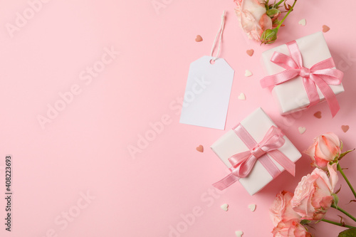 Concept of Valentine's day with roses and gift boxes on pink background © Atlas