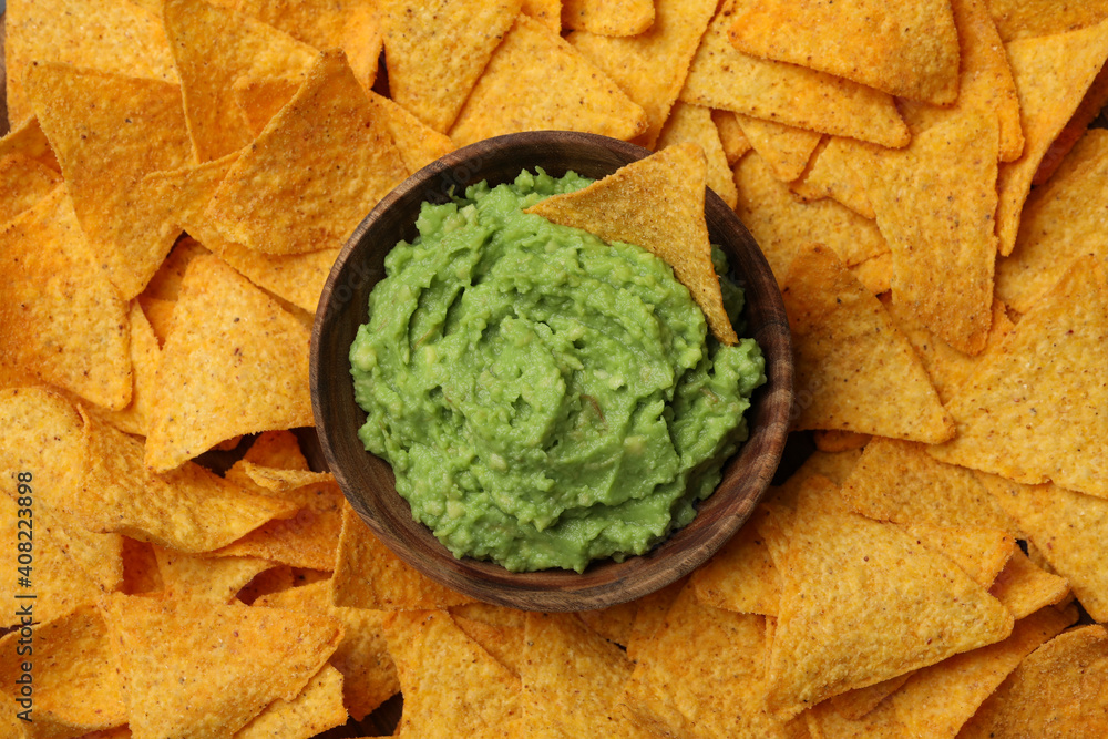 Bowl of guacamole on chips background, top view Bowl of guacamole on chips background, top view