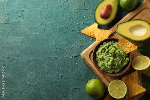 Foto Concept of tasty eating with bowl of guacamole on green textured background