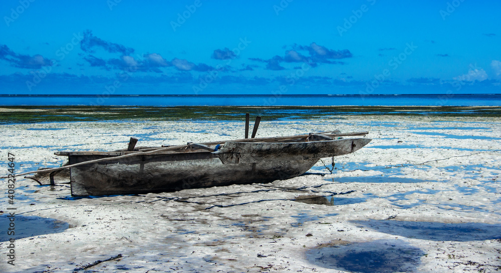 Old wooden fishing boat in the Indian ocean off the coast of Zanzibar by sunny day