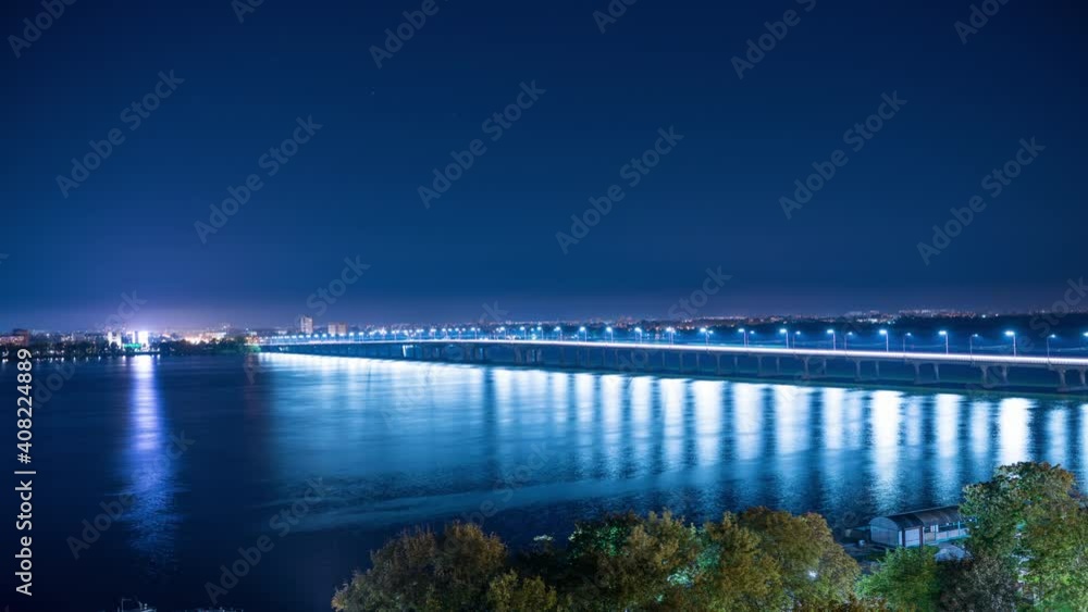 Beautiful long bridge in bright cold lights across a gleaming river, 4K UHD time lapse Beautiful long bridge in bright cold lights across a gleaming river, 4K UHD time lapse