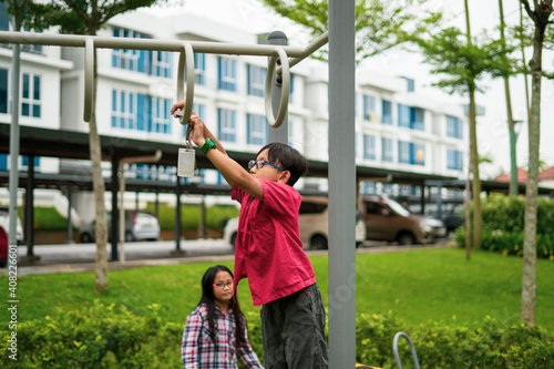 Canvas Print Young asian children hang on the monkey bar