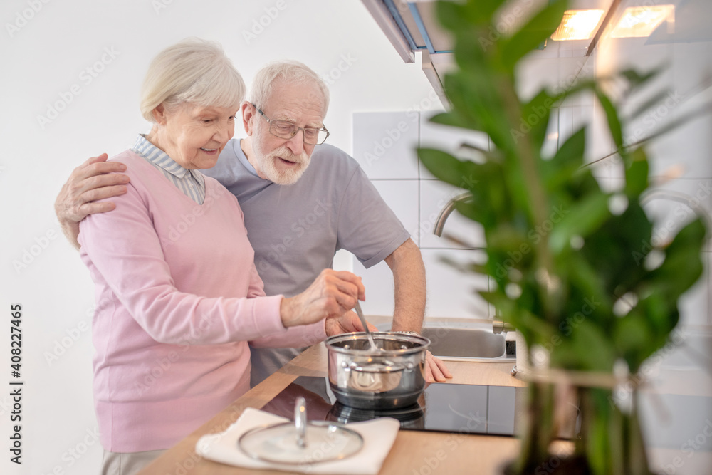 Senior couple cooking together in the kitchen and feeling good Senior couple cooking together in the kitchen and feeling good