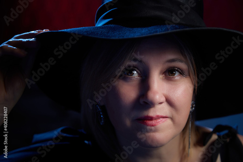 Portrait of fat plump chubby middle-aged woman with hat and black dress. Model looking as lady posing in studio.
