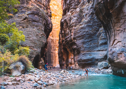 Orange glow hits the canyon walls in The Narrows of Zion National Park