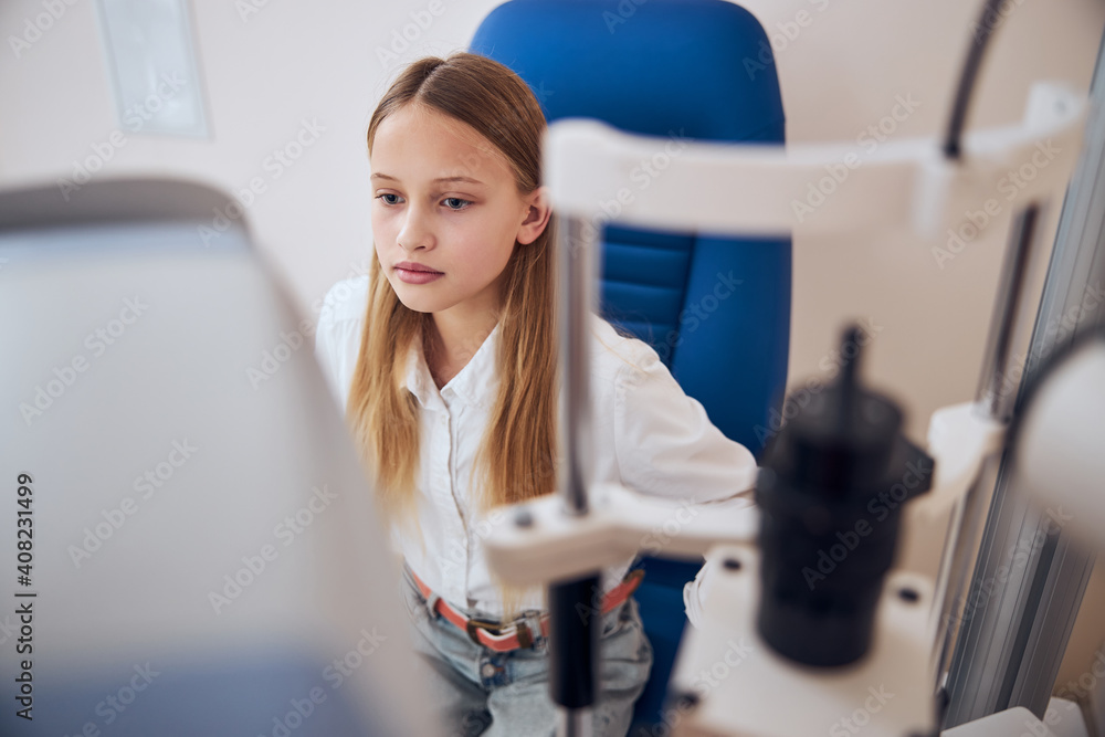 Cute female child spending time in office of pediatric ophthalmologist Cute female child spending time in office of pediatric ophthalmologist