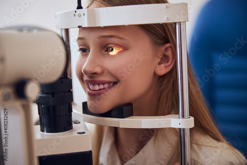 Fototapeta Naklejka Na Ścianę i Meble -  Stylish teenager girl in white shirt at the doctor optometrist appointment