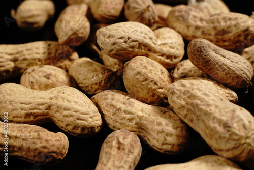 Lots of shelled peanuts on a black background. Closeup.