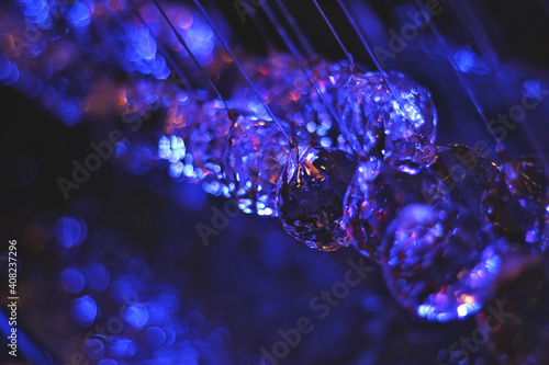 Glass balls hang over water fountain with neon lights