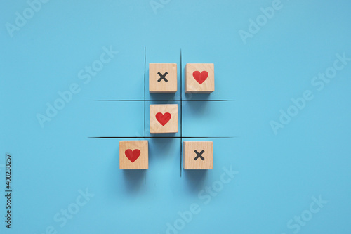 A game of tic-tac-toe with hearts and crosses. Valentine's Day greeting card. The victory of love in life