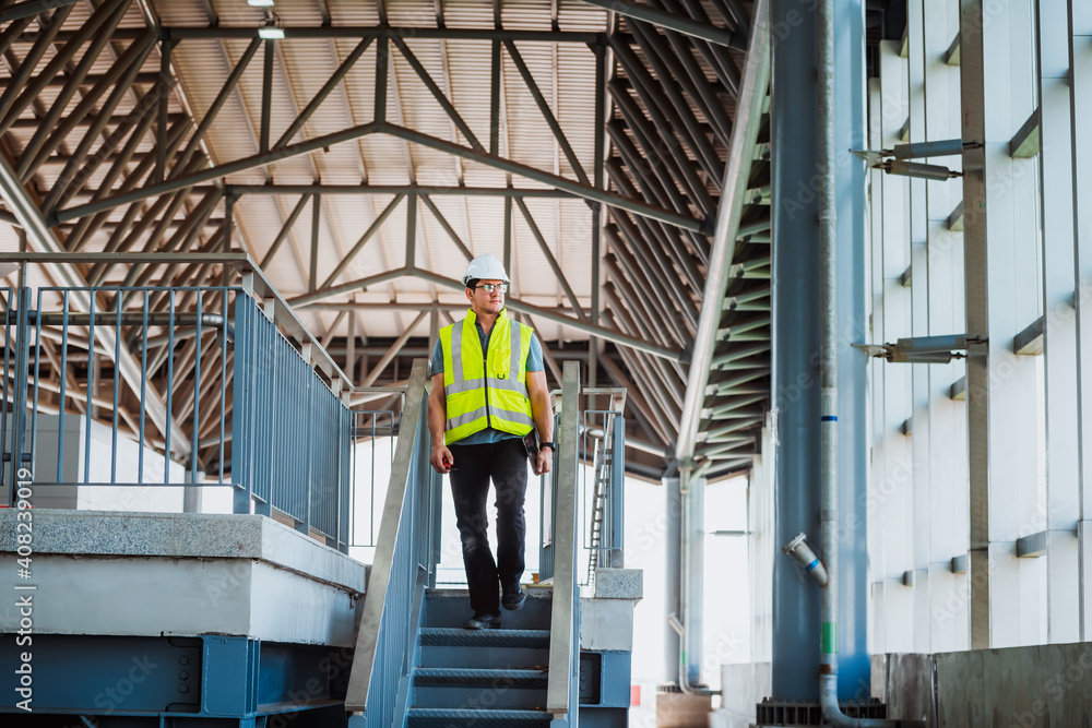 Portrait engineer under inspection and checking construction process railway and checking work on railroad station .Engineer wearing safety uniform and safety helmet in work.