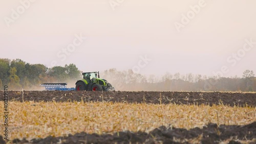 Wallpaper Mural Tractor in the field. A modern tractor plows the field. Green tractor plows the field Torontodigital.ca