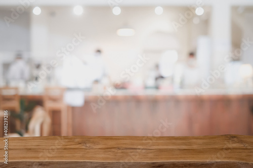 Wooden board empty table in front of blurred restaurant or coffee shop background. can be used for display or montage your products.Mock up for display of product.