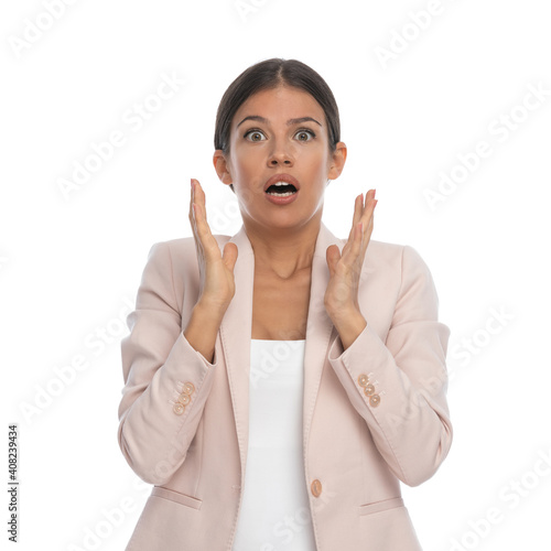 scared young woman holding hands up, opening mouth and screaming photo