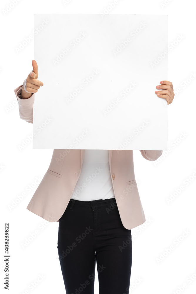 young businesswoman hiding behind empty board and pointing fingers young businesswoman hiding behind empty board and pointing fingers