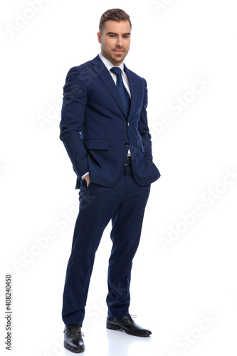 Canvas Print smiling young man in navy blue suit holding hands in pockets