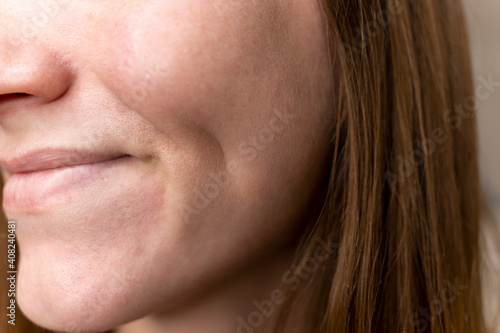 Fotografie A woman smiles with a dimple on her cheek