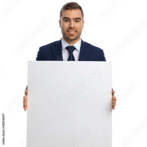 portrait of happy elegant guy presenting empty board and smiling