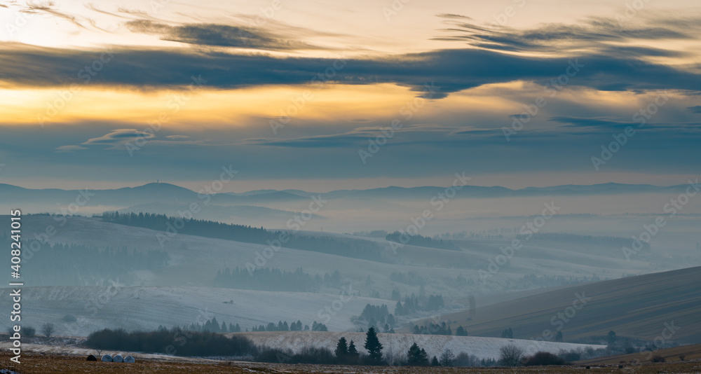 Beautiful landscape of Slovakia - undulating fields, mountains, blown by snow, shrouded in morning mist
