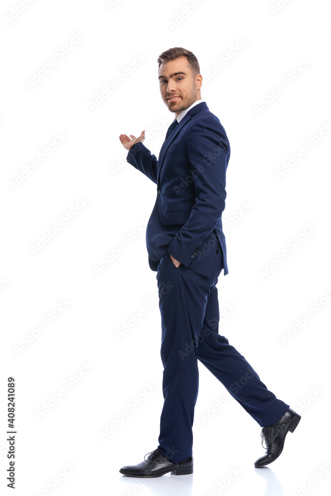 handsome bearded guy in navy blue suit presenting to side handsome bearded guy in navy blue suit presenting to side