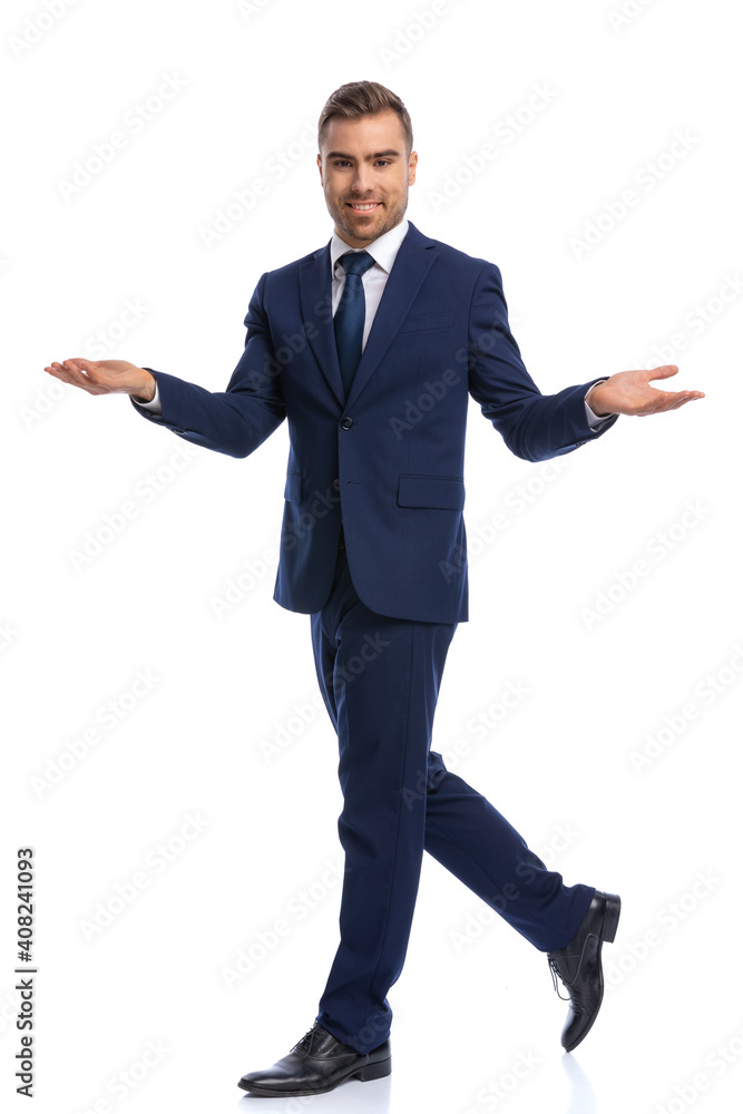 smiling young businessman in navy blue suit opening hands and presenting smiling young businessman in navy blue suit opening hands and presenting