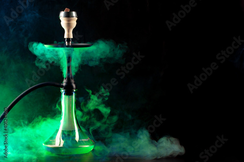 Smoking hookah on black background with color fog photo