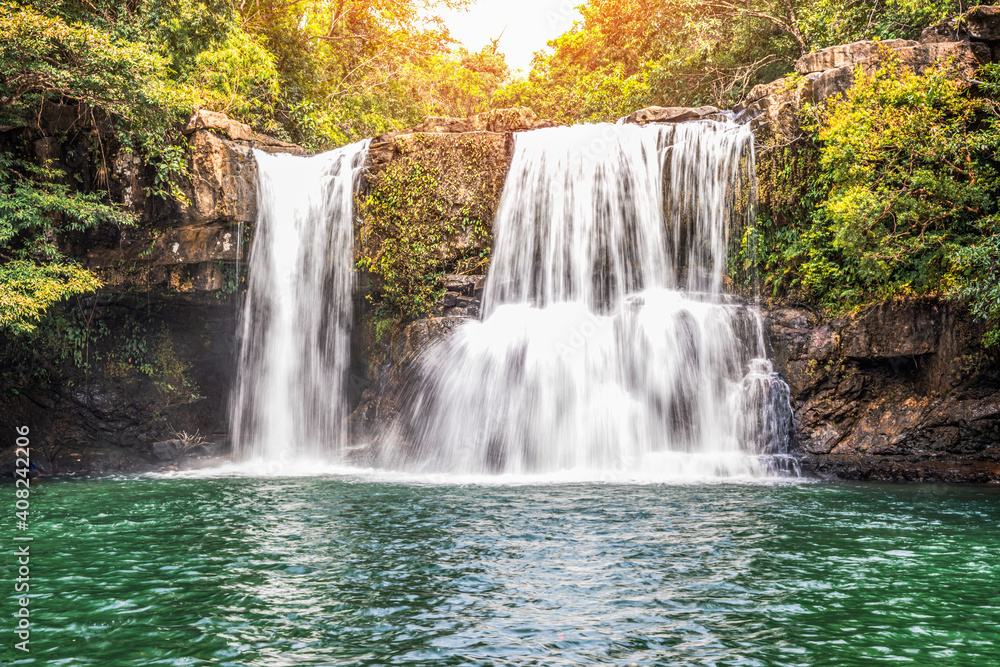 Fototapeta premium Beautiful waterfall with sunlight in jungle, Khlong Chao waterfall in Ko kood island, Thailand