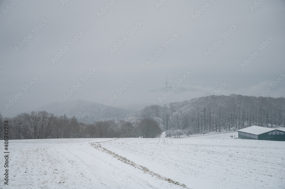 verschneite Winterlandschaft mit einem Funkturm im nebeligen Himmel verschneite Winterlandschaft mit einem Funkturm im nebeligen Himmel