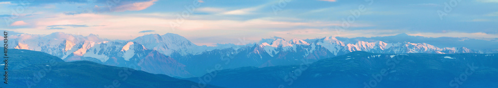 Large panorama. Mountain peaks in the sunset light.