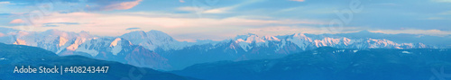 Large panorama. Mountain peaks in the sunset light.