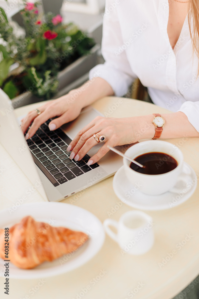 Hands of a woman with coffee and laptop in a summer outdoor cafe Hands of a woman with coffee and laptop in a summer outdoor cafe