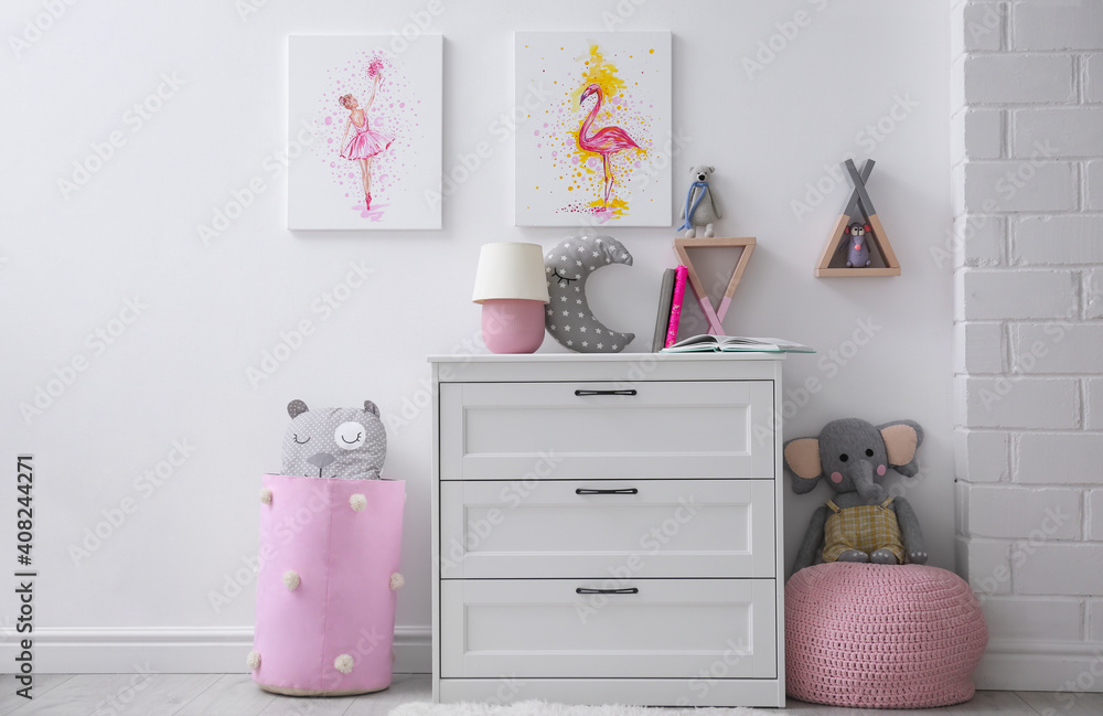 Fototapeta premium Chest of drawers and beautiful pictures in children's room. Interior design
