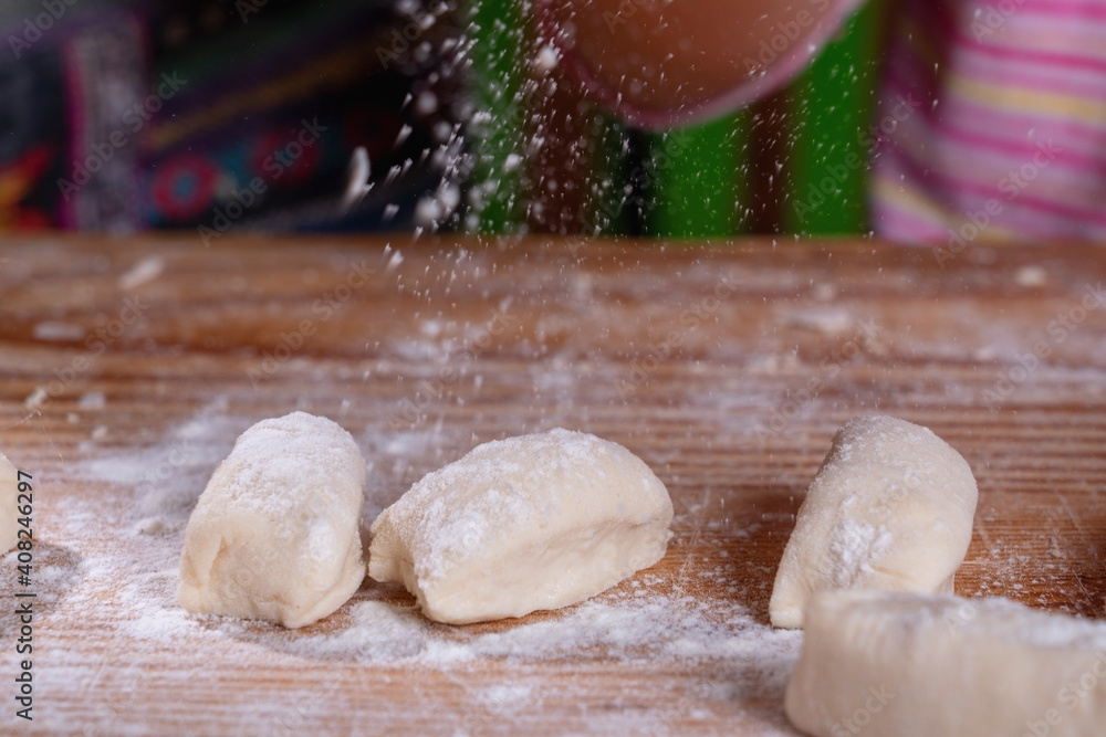 Close up female pastry chef preparing dough on wooden board. Close up female pastry chef preparing dough on wooden board.