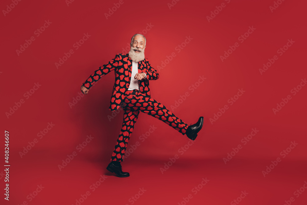 Fototapeta premium Photo of funny positive gentleman walk march look camera wear heart print suit footwear isolated red background
