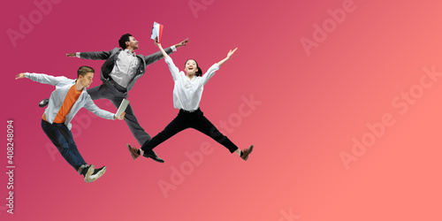 Happiness. Happy office workers jumping and dancing in casual clothes or suit isolated on gradient neon fluid background. Business  start-up  working open-space  motion  action concept. Creative