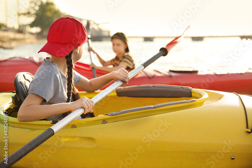 Little children kayaking on river. Summer camp activity
