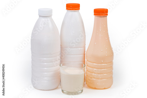 Plastic bottles and glass of various drinkable fermented dairy products photo