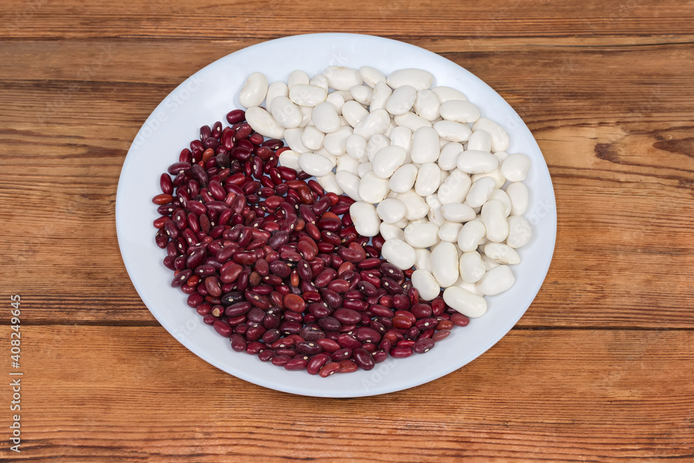 White and red kidney beans on dish on rustic table White and red kidney beans on dish on rustic table