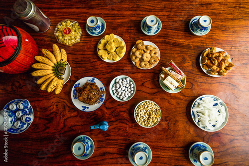 View of Vietnamese food for Tet holiday in spring, jam is traditional food and teapot set on lunar new year. Dried fruit and jam as tradition dessert - Mut Tet on wooden table. photo