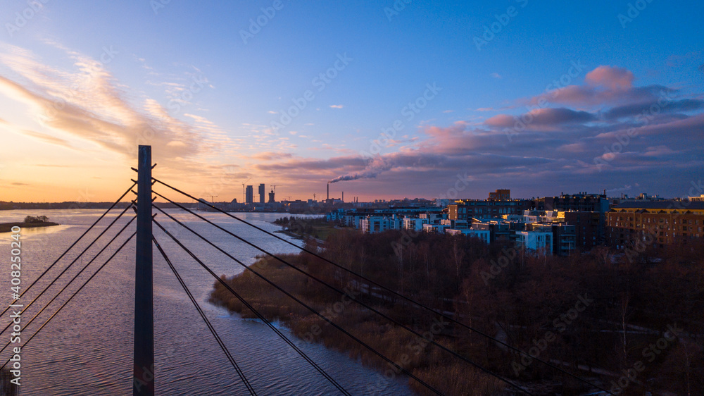 Sunny cloudscape over the city skyline. Arabianranta bridge over the bay at Vanhankaupungilahti in Helsinki, Finland.