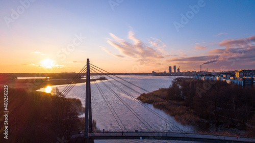 Sunny cloudscape over the city skyline. Arabianranta bridge over the bay at Vanhankaupungilahti in Helsinki, Finland.