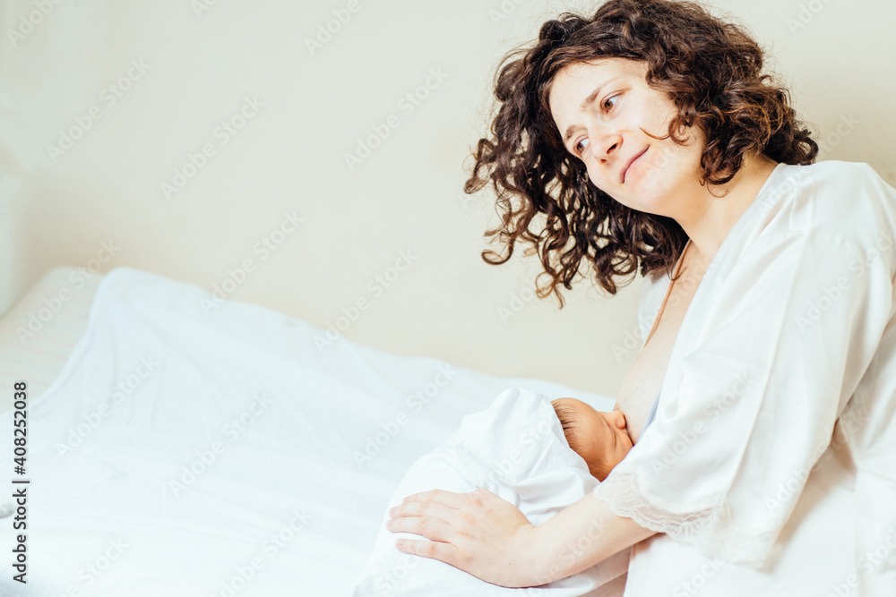 Young mother holding her newborn child. Mom nursing baby. Woman and new born boy in maternity hospital room. Mom lying on bed breast feeding. Young mother holding her newborn child. Mom nursing baby. Woman and new born boy in maternity hospital room. Mom lying on bed breast feeding.