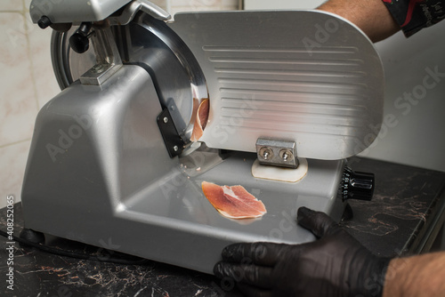 Foto The process of slicing ham on a slicer