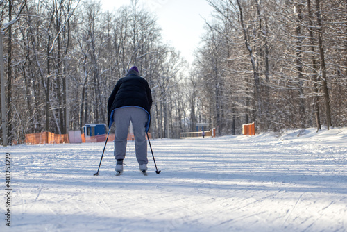 People skiing on a ski track in the forest on a sunny frosty day in winter. Winter sports. Active and healthy lifestyle. Sportsman on ski cross-country in mountain. Snow landscape.