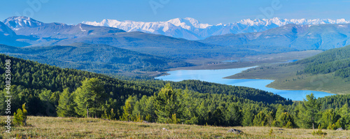 Mountain valley with a lake. Snow-capped peaks.