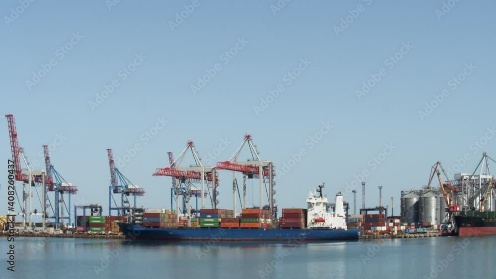 Gantry crane is unloading a containers from a Cargo in the port at daytime. Time-lapse. Gantry crane is unloading a containers from a Cargo in the port at daytime. Time-lapse.